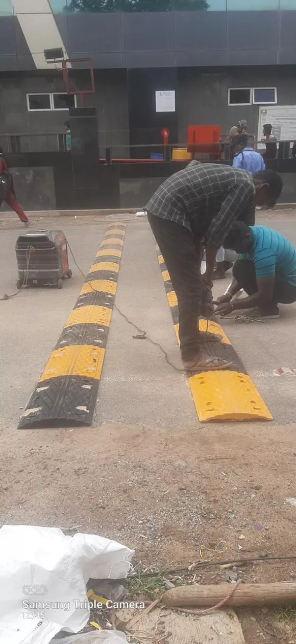 Deepam Road Marking crew installing a rubber speed breaker outside a facility entrance