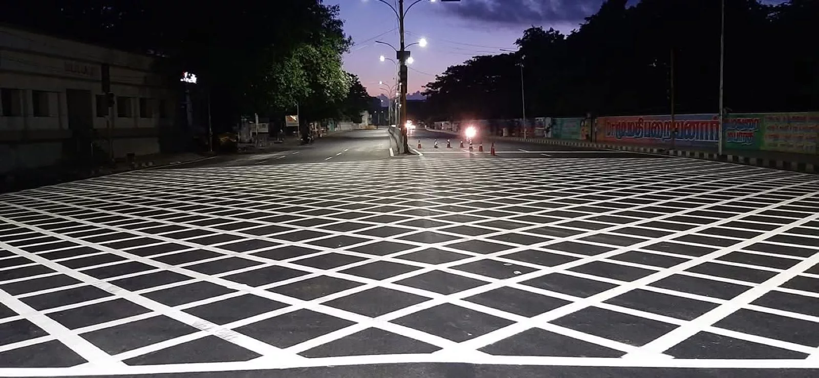 Completed thermoplastic box-grid junction road marking at dusk
