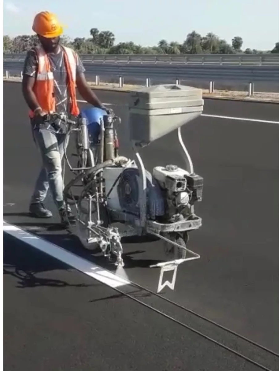 Thermoplastic spray machine applying a highway line